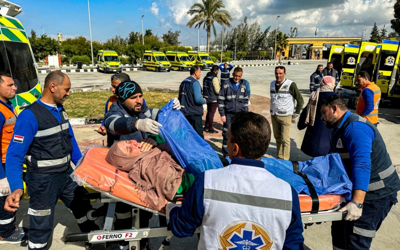 Une femme palestinienne blessée est transportée sur un brancard par des ambulanciers du Croissant-Rouge égyptien après avoir été évacuée de la bande de Gaza par le poste-frontière de Rafah, le 3 février (AFP)