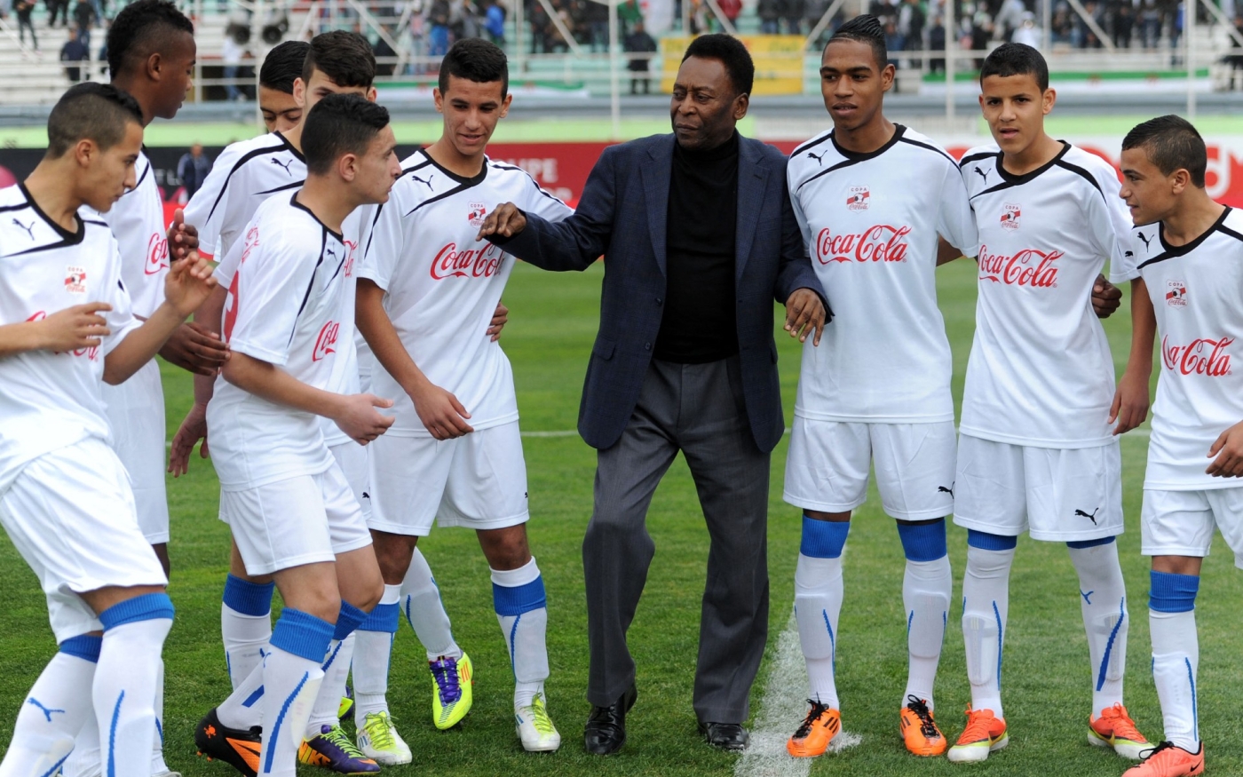 Pelé pose avec de jeunes footballeurs au stade Mustapha-Tchaker de Blida (Algérie), le 5 mars 2014 (AFP)