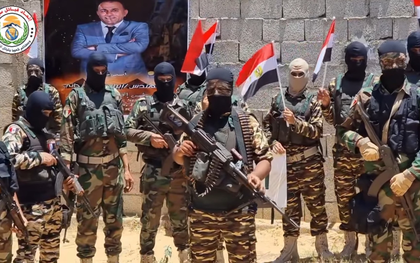 Membres de la milice affiliée à l’Union des tribus du Sinaï, avec en arrière-pan un poster d’Organi (Facebook/capture d’écran)