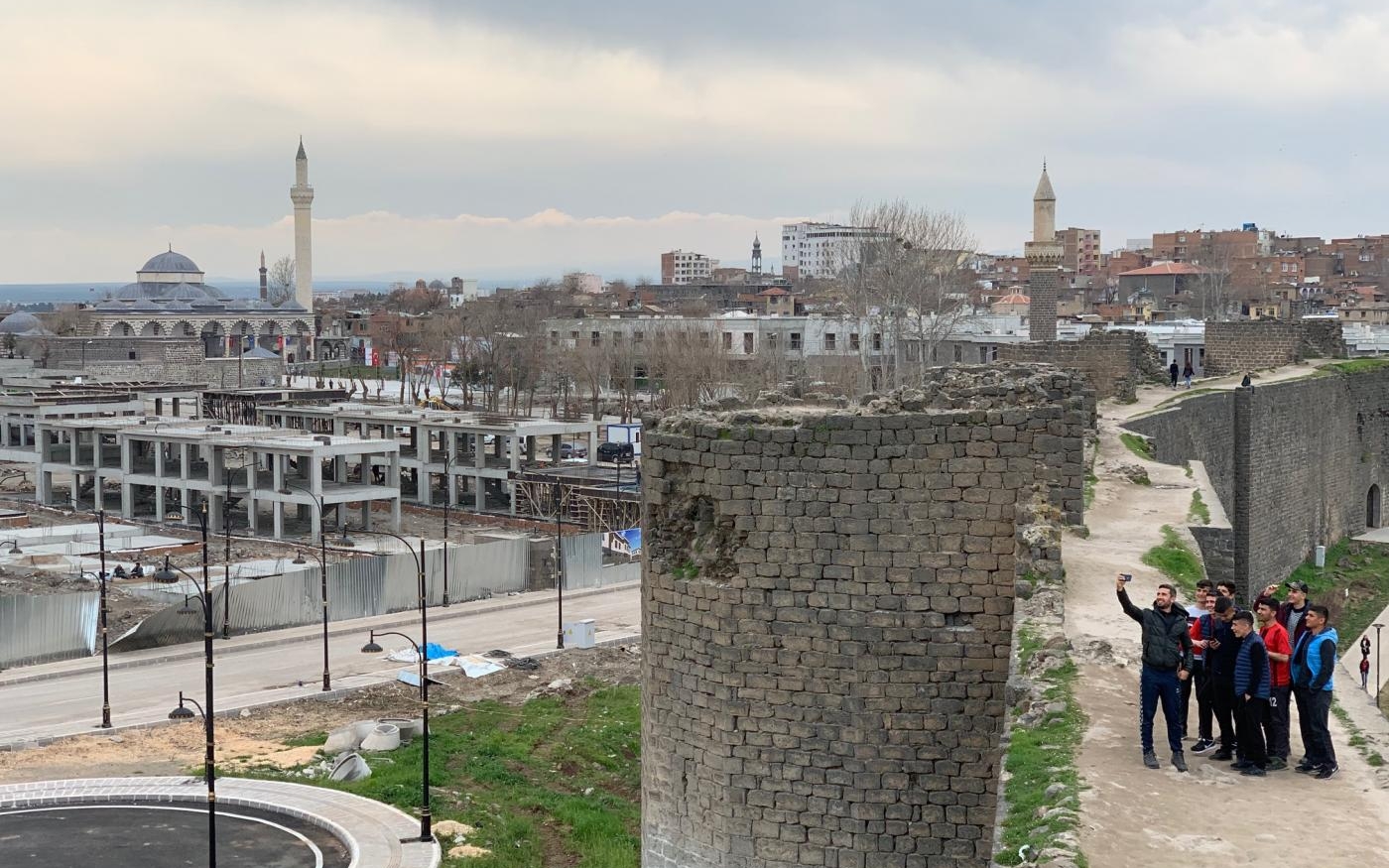 Des habitants de Diyarbakır se photographient devant un pan des remparts de la vieille ville, inscrite au patrimoine mondial de l’UNESCO (Ragip Soylu/MEE)