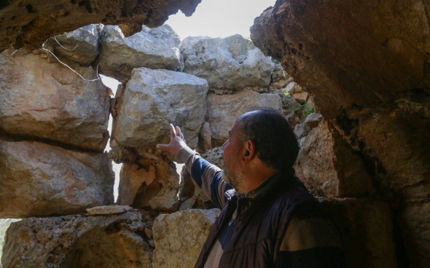 Zouhair Hassoun, gardien de la forteresse de Saladin, montre les dégâts causés par le séisme du 6 février 2023 (AFP/Louai Beshara)