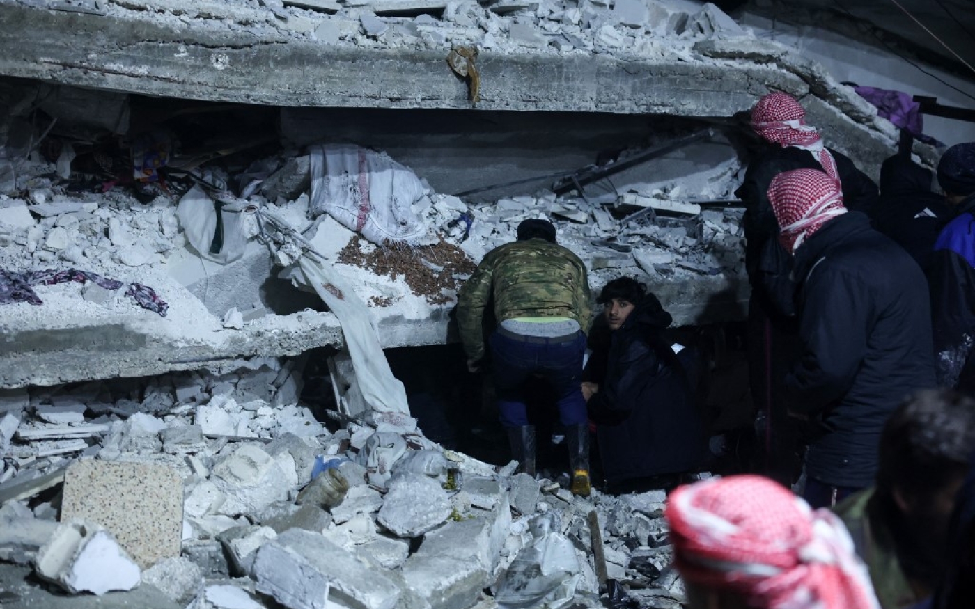 Des habitants recherchent des survivants parmi les décombres des immeubles effondrés, à Azmarin, au nord de la Syrie, près de la frontière avec la Turquie, le 6 février 2023 (AFP/Omar Haj Kadour)