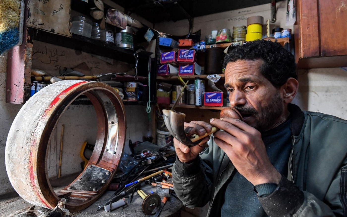 L’artisan Khaled ben Khemis teste les les anches – petites flûtes – d’un mezoued, près de Tunis, le 24 mai 2023 (AFP/Fethi Belaid)