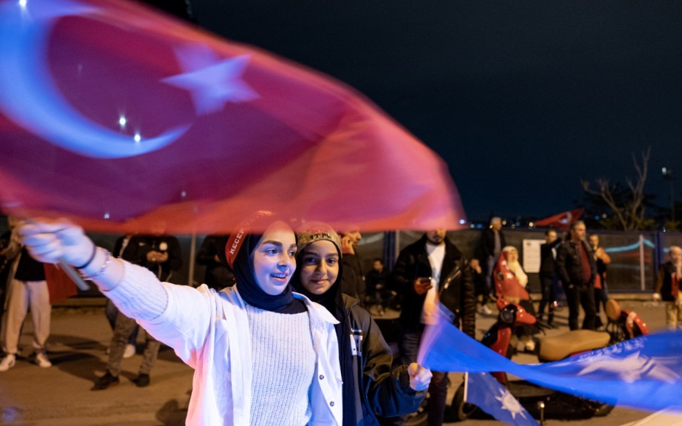 Des supportrices de l’AKP attendent les résultats des votes dans la rue à Istanbul, le 14 mai 2023 (AFP/Umit Turhan Coskun)