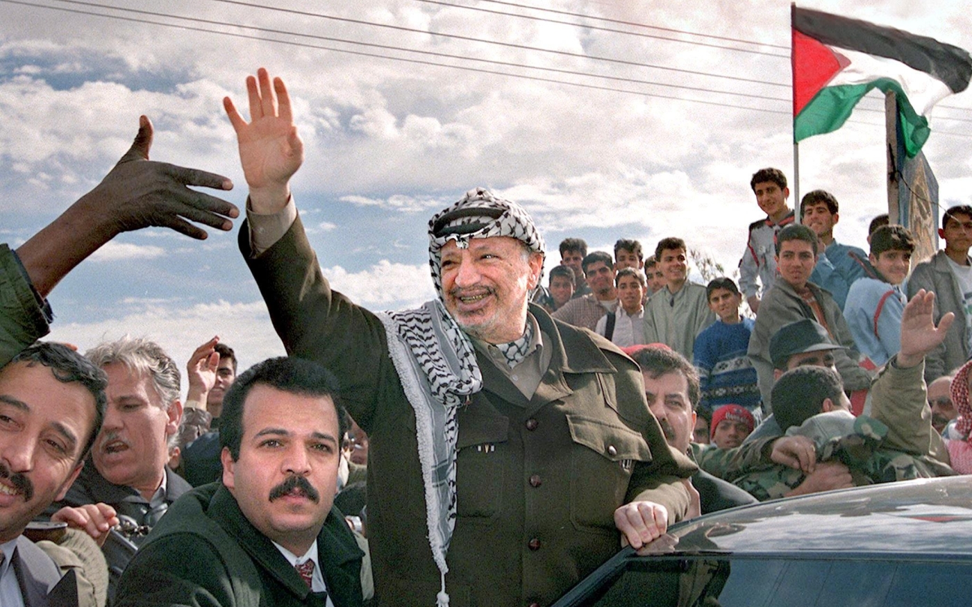 Le président palestinien de l’époque, Yasser Arafat, salue la foule qui s’est rassemblée pour l’accueillir à Rafah, dans la bande de Gaza, le 27 février 1998 (AFP/Fayez Nureldine)