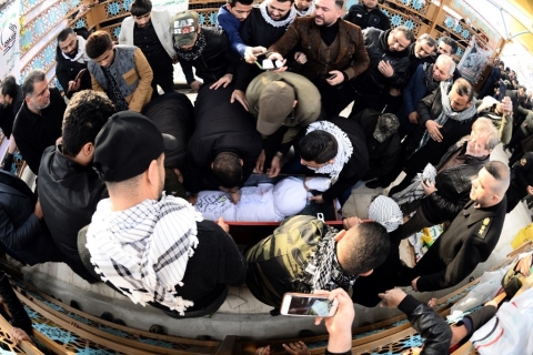 Hashed al-Shaabi members gather around the coffin of Muhandis in Najaf on Wednesday (AFP)