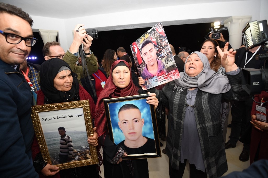 Des Tunisiennes brandissent des portraits de leurs fils à l’occasion d’une audition de l’Instance vérité et dignité, le 17 novembre 2016 (AFP/Fethi Belaïd)