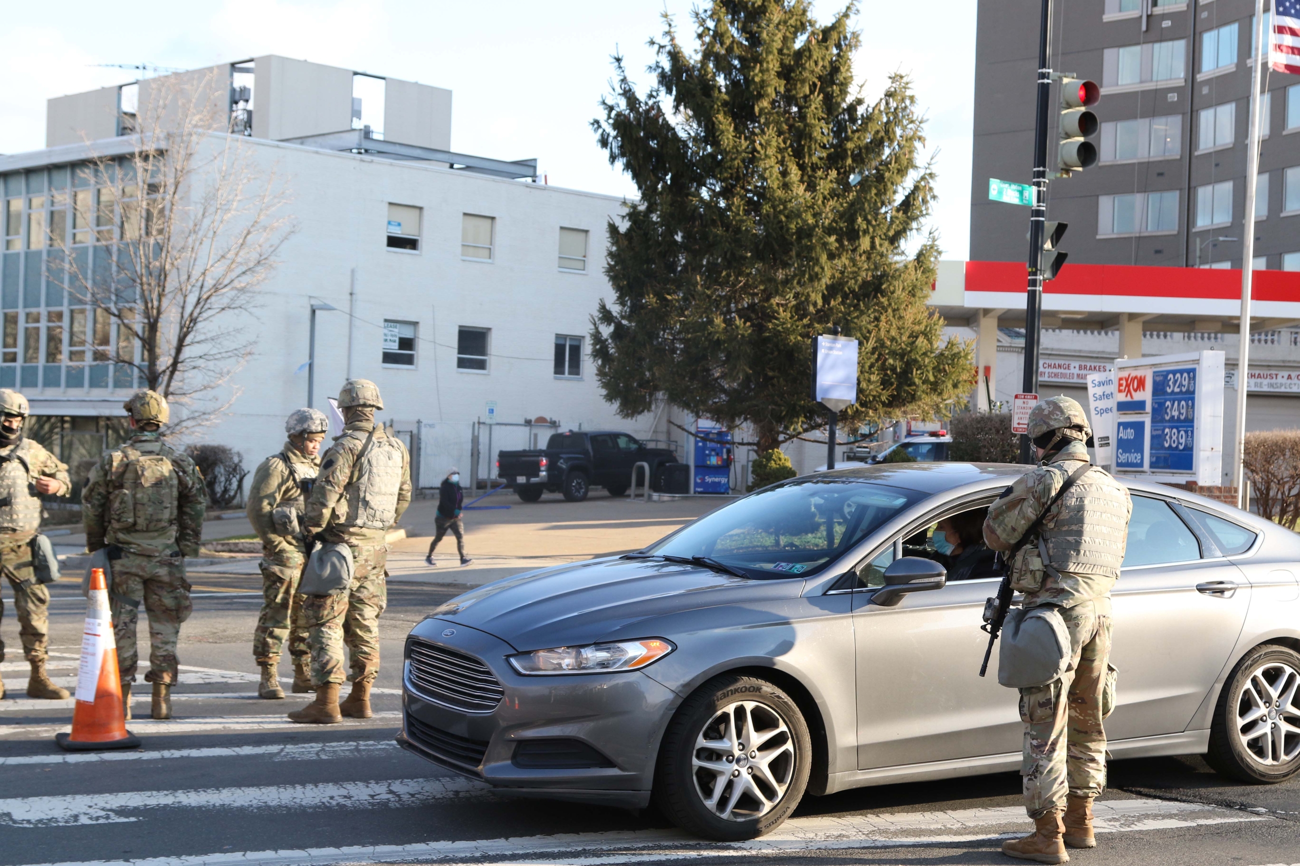 A National Guard member stops a car at a checkpoint 