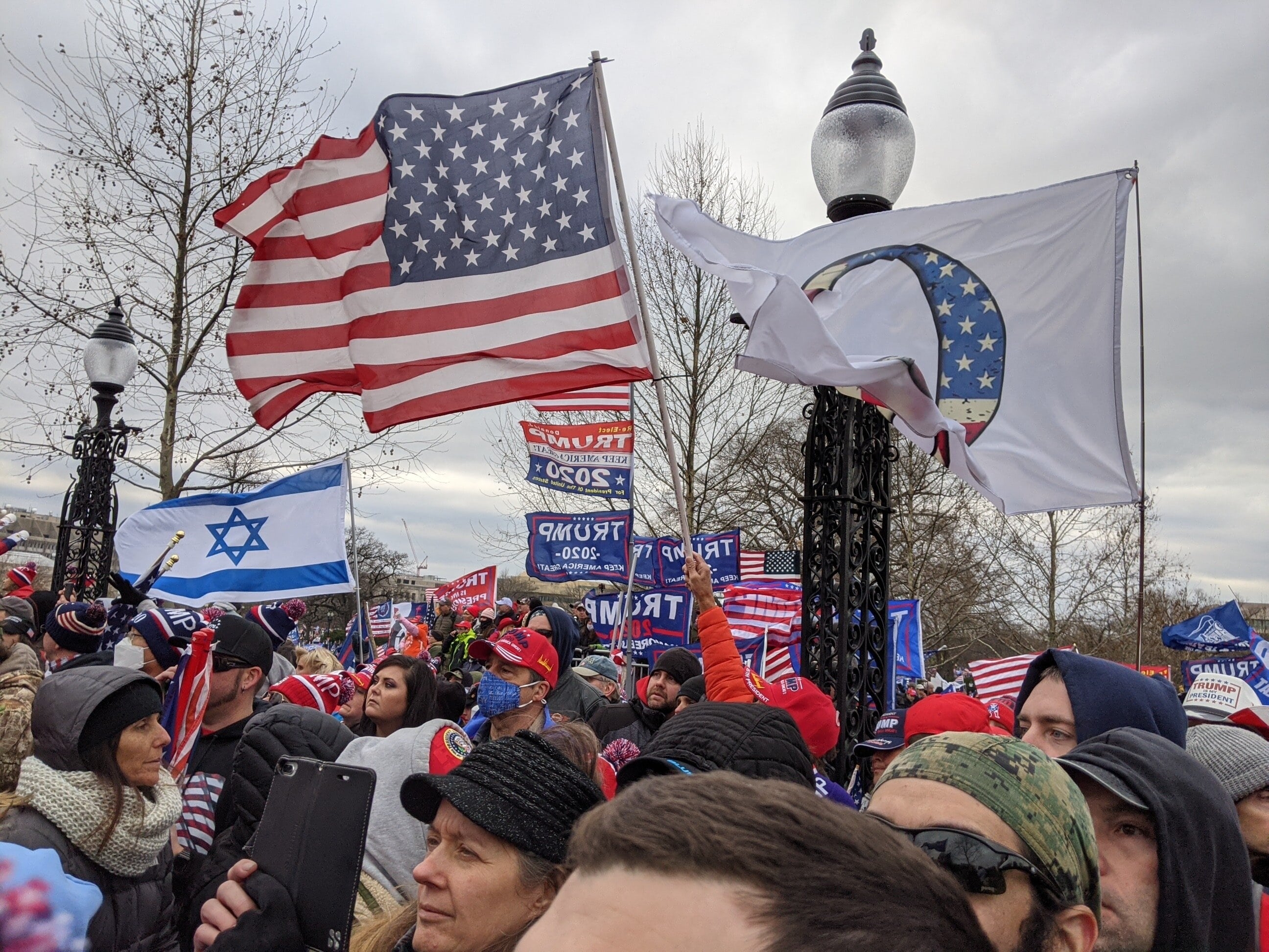 Un drapeau israélien près d’un drapeau QAnon (théorie du complot d’extrême droite) dans le rassemblement des partisans de Trump près du Capitole américain (MEE/Ali Harb)