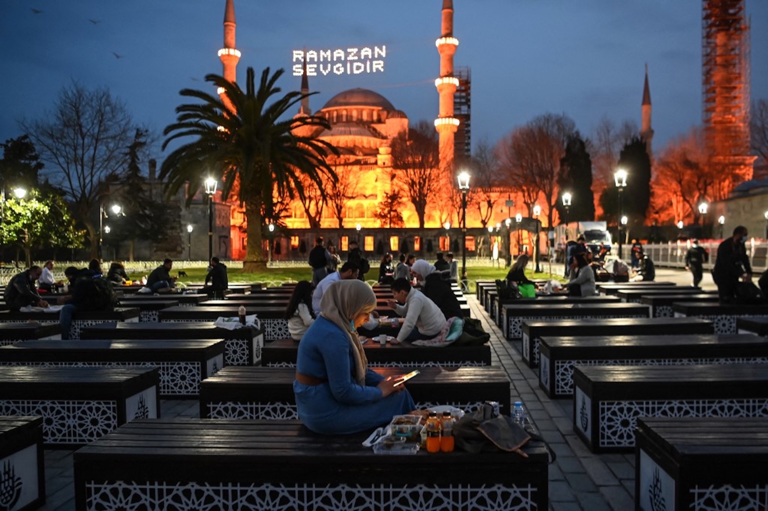 TURQUIE. Les musulmans partagent l’iftar, sur la place Sultanahmet, avec la mosquée bleue en arrière-plan, à Istanbul le 13 avril 2021 (AFP)