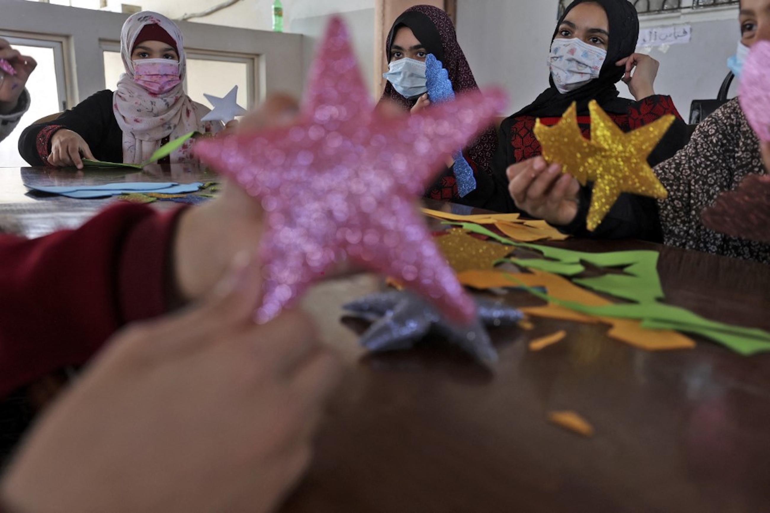 BANDE DE GAZA. De jeunes Palestiniennes participent à un atelier pour apprendre à fabriquer des étoiles ornementales pour le mois sacré, à Gaza, le 15 avril 2021 (AFP)
