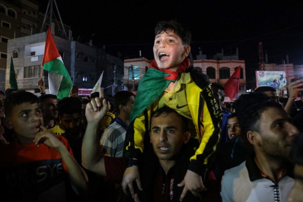 A child screams with joy as people come outside to celebrate the beginning of the ceasefire in Gaza City