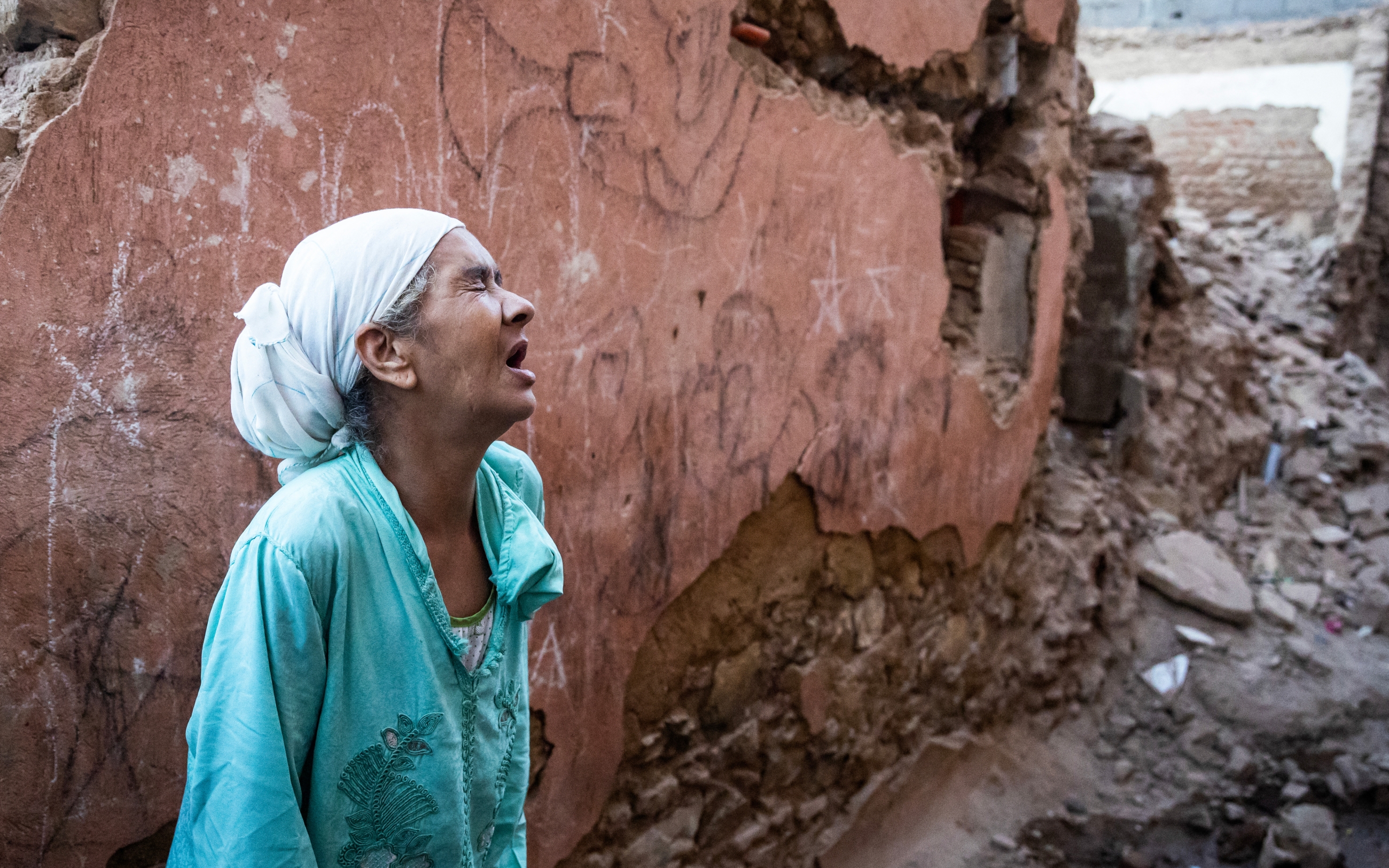 Une Marocaine devant sa maison endommagée par le tremblement de terre, dans la vieille ville de Marrakech, le 9 septembre 2023 (AFP/Fadel Senna)