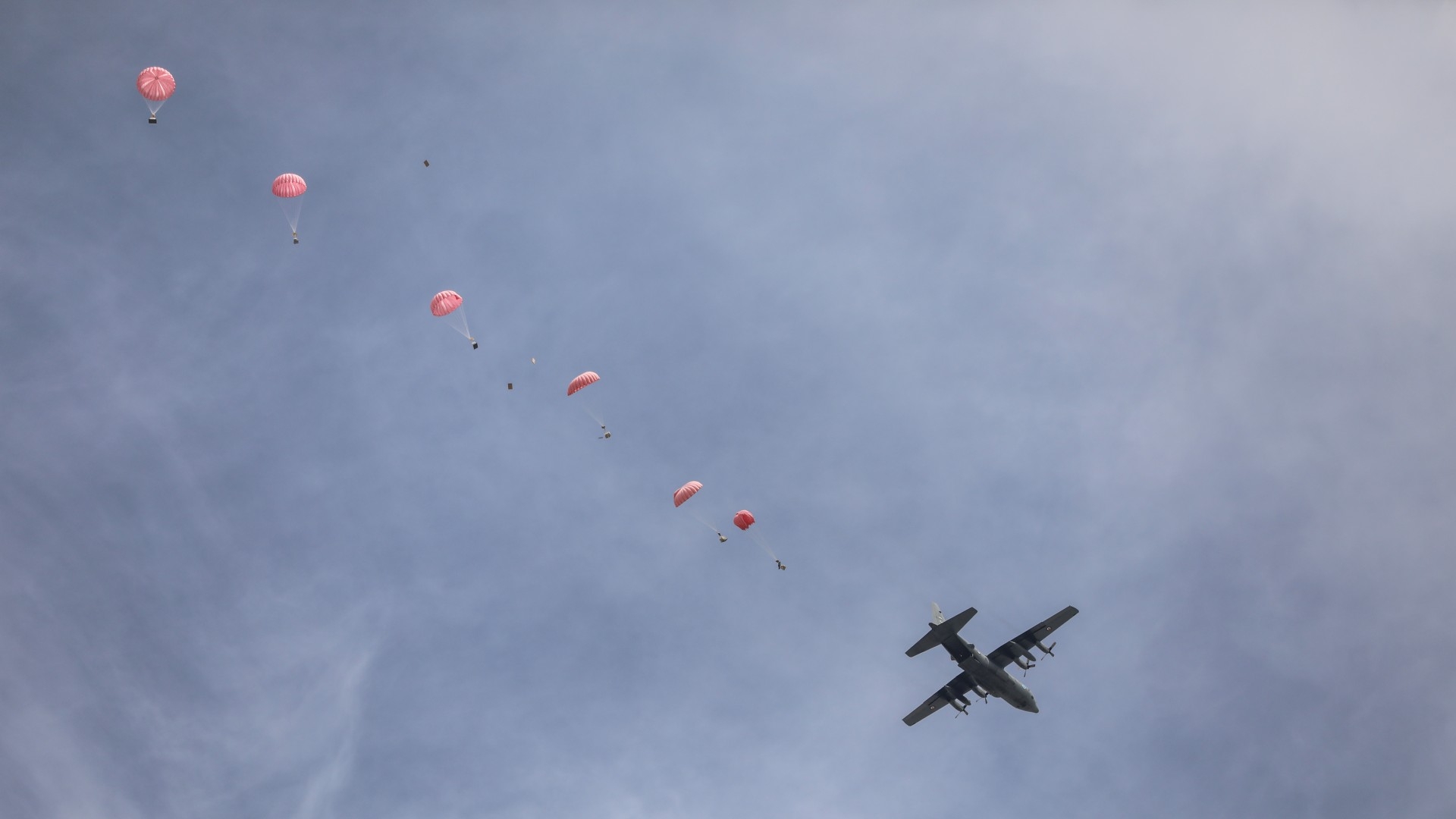 A military plane airdrops small batches of aid on war-ravaged Gaza. Critics have said airdrops are dangerous and merely designed to divert public anger over the mounting Palestinian death toll (MEE/Mohammed al-Hajjar)