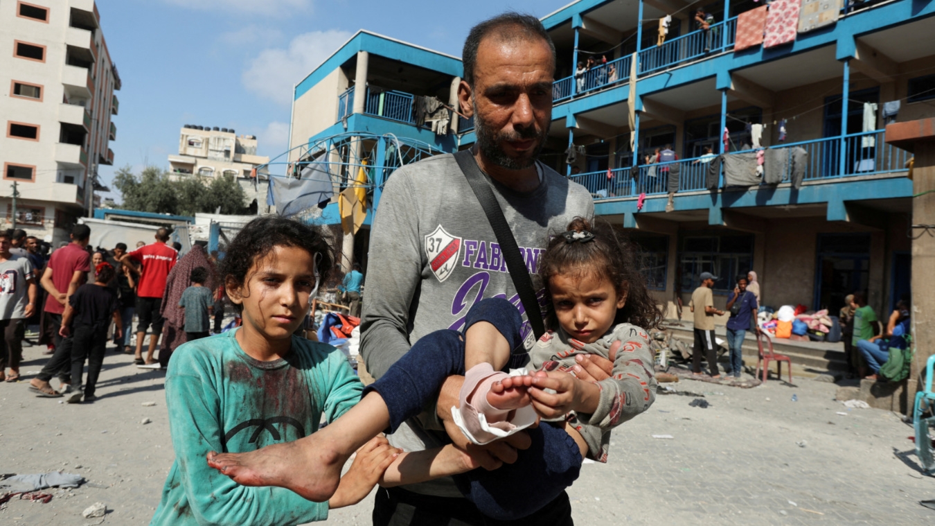 Palestinians flee from a Unrwa school targeted by an Israeli air strike (Reuters/Ramadan Abed)