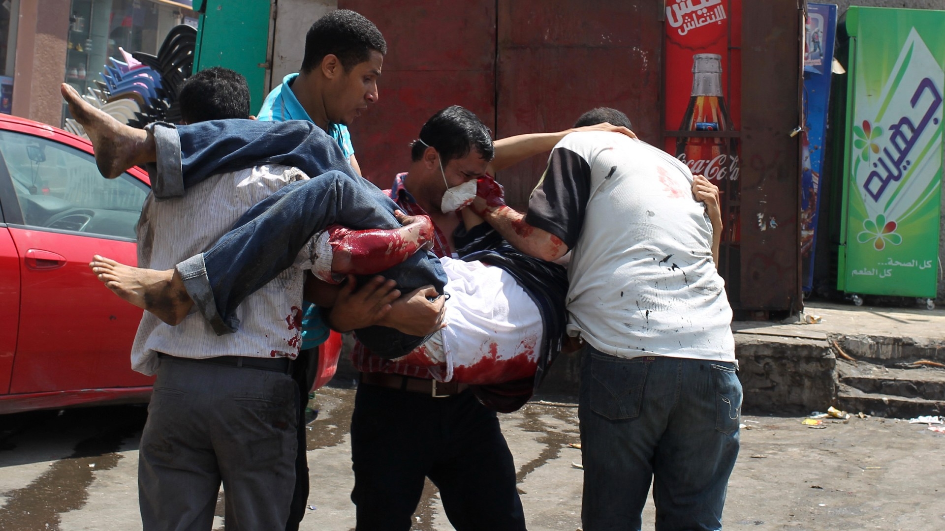 Supporters of deposed Egyptian President Mohamed Morsi carry a protester wounded by security forces in the area of Rabaa al-Adawiya square, where they are camping, in Cairo (Reuters)