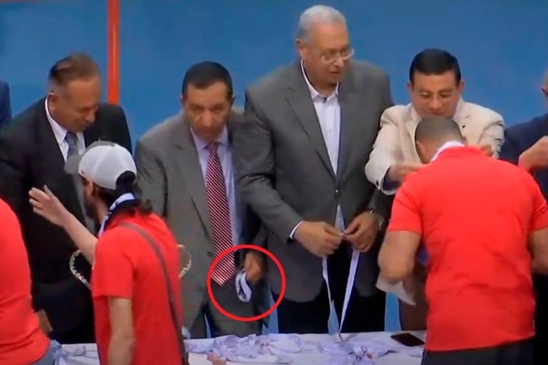 Dans cette séquence ont voit l’ex-vice-président des Zamalek cacher en douce une médaille dans sa poche (capture d’écran)