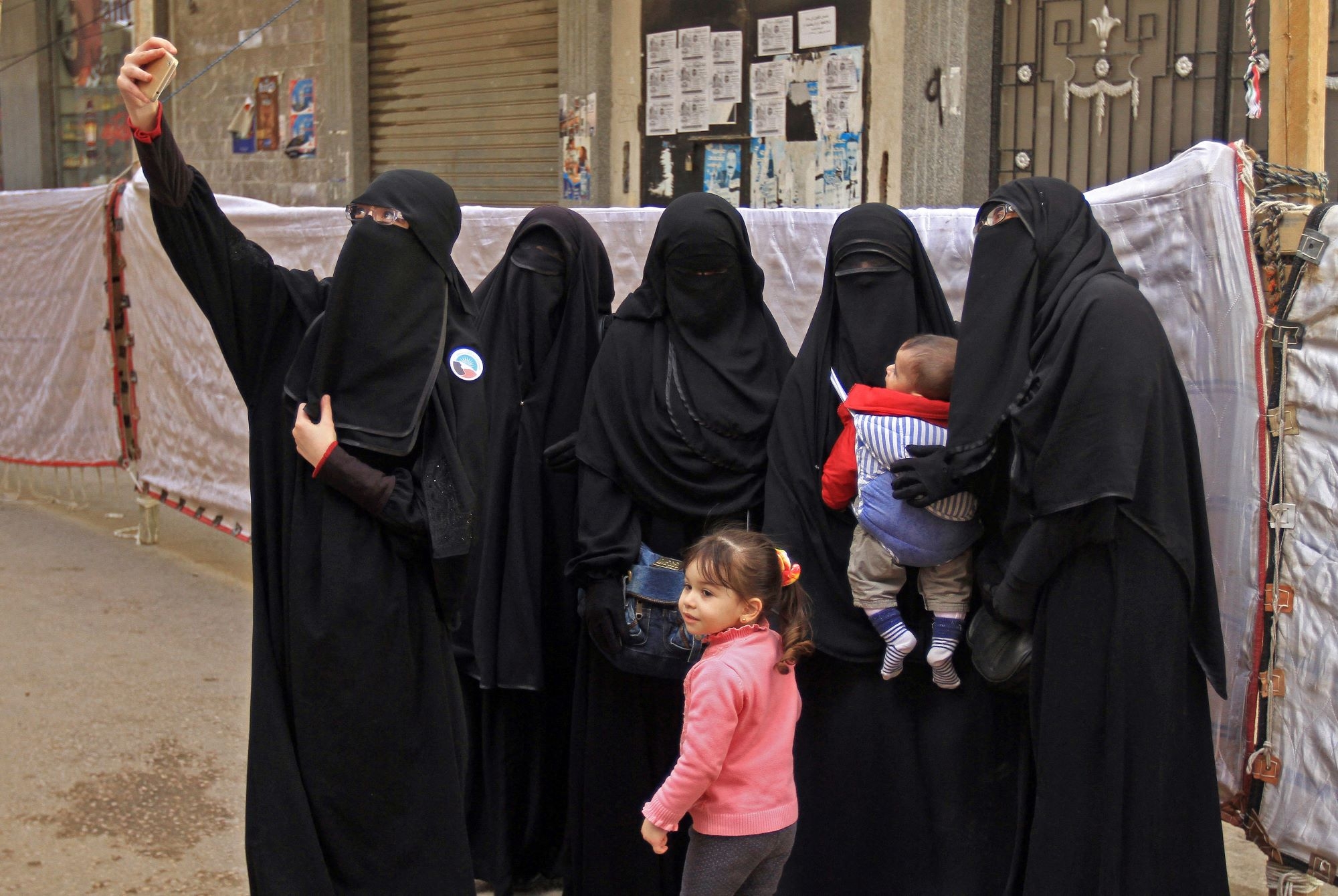 Des Égyptiennes portant des niqabs posent pour une photo devant un bureau de vote à Alexandrie en 2018 (AFP)