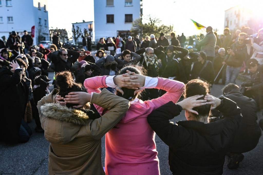Des jeunes reconstituent une interpellation lors d’une manifestation à Mantes-la-Jolie, le 12 décembre 2018, en soutien aux lycéens interpellés en banlieue parisienne. (AFP/Alain Jocard)