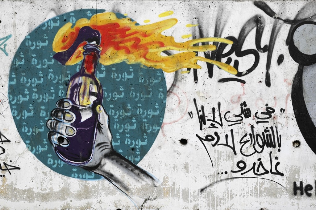 Graffiti d’une main tenant un cocktail molotov sur un mur du centre de Beyrouth, une photo prise le 5 novembre 2019 alors que des dizaines de milliers de Libanais manifestent pour dénoncer l’élite politique (AFP/Fayez Nureldine)