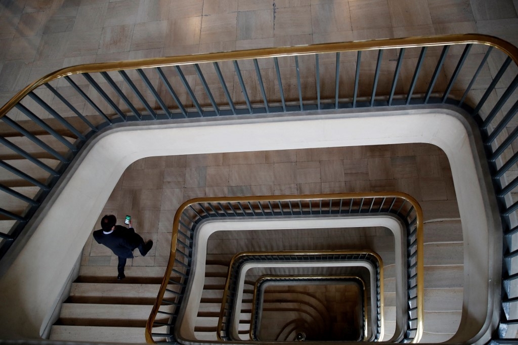 Un fonctionnaire descend les escaliers avant la visite du président français au Centre de crise et de soutien du ministère français des Affaires étrangères, au Quai d’Orsay, à Paris (AFP/François Mori)