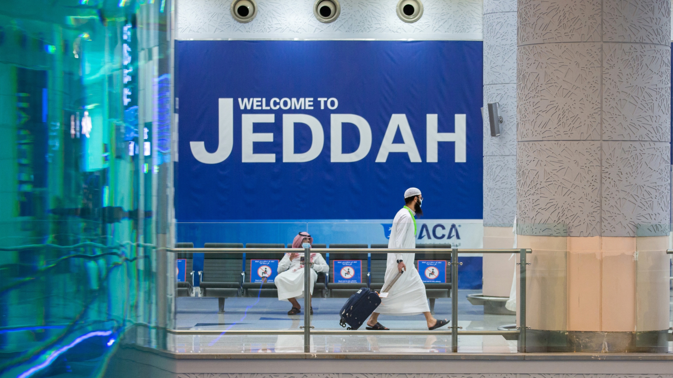 A handout picture provided by the Saudi Ministry of Media on July 25, 2020, shows a traveller walking with his luggage at Jeddah's King Abdulaziz International Airport (AFP)