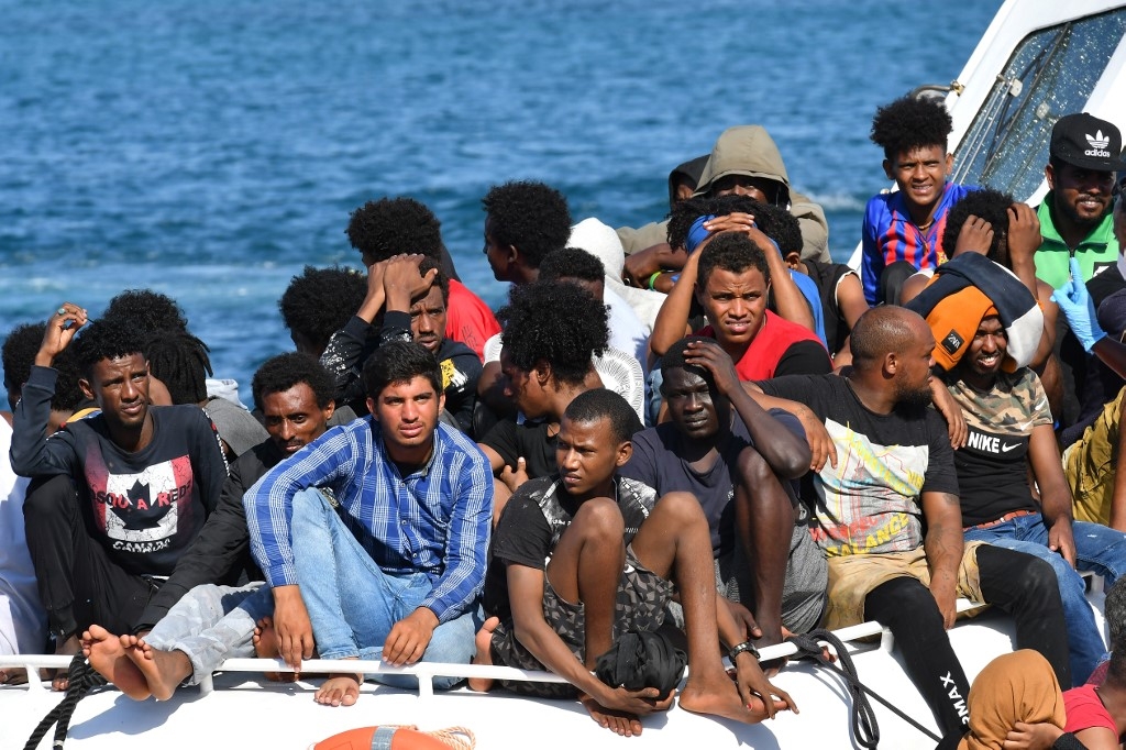 Des migrants de Tunisie et de Libye arrivent à bord d’un bateau italien des garde-côtes sur l’île de Lampedusa le 1er août 2020 (AFP)