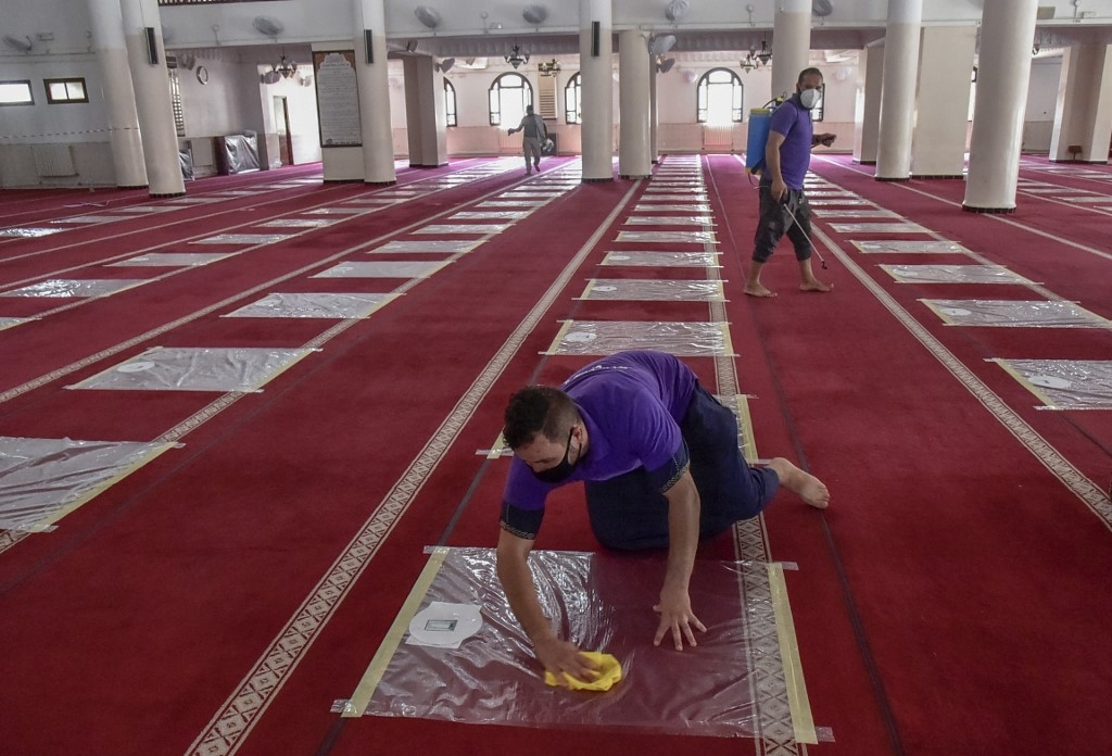 Des volontaires désinfectent la salle de prière d’une mosquée de Kouba, à Alger, le 15 août 2020 (AFP) 