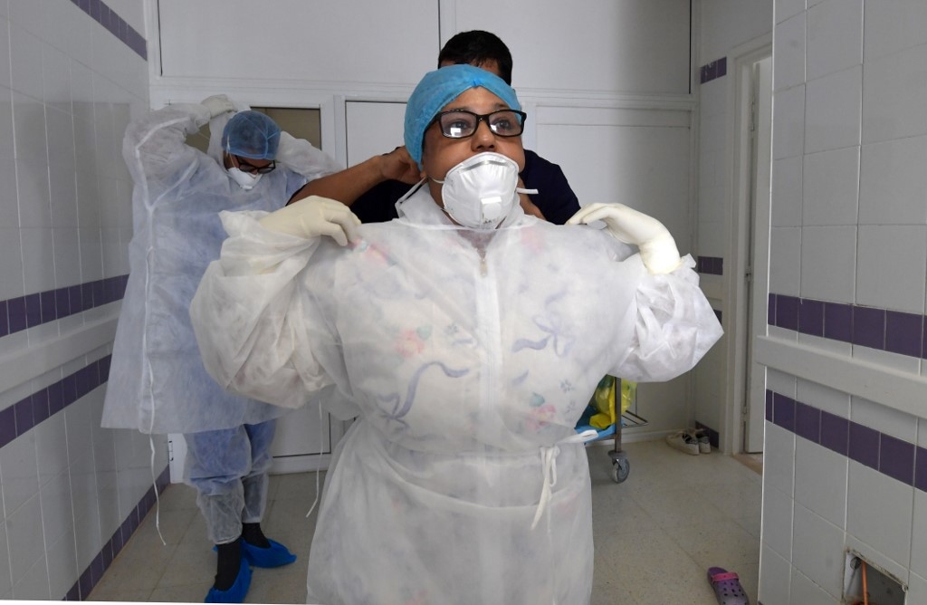 Des médecins d’une unité de soins intensifs à l’hôpital de Gabès, au sud-ouest de la Tunisie, se préparent alors que la région connaît un pic de contaminations, le 26 août 2020 (AFP)