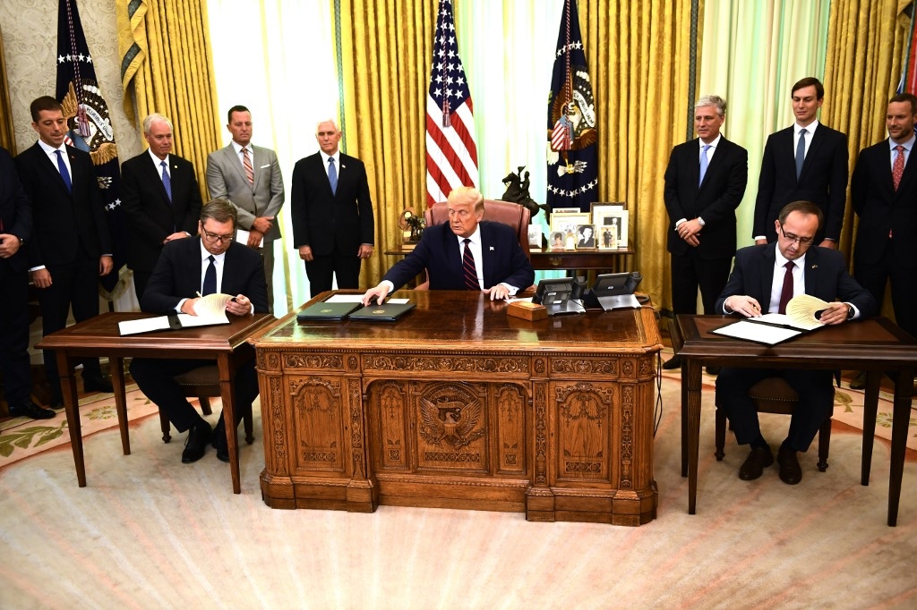 Donald Trump watches as Kosovo Prime Minister Avdullah Hoti (R) and Serbian President Aleksandar Vucic (L) sign an accord