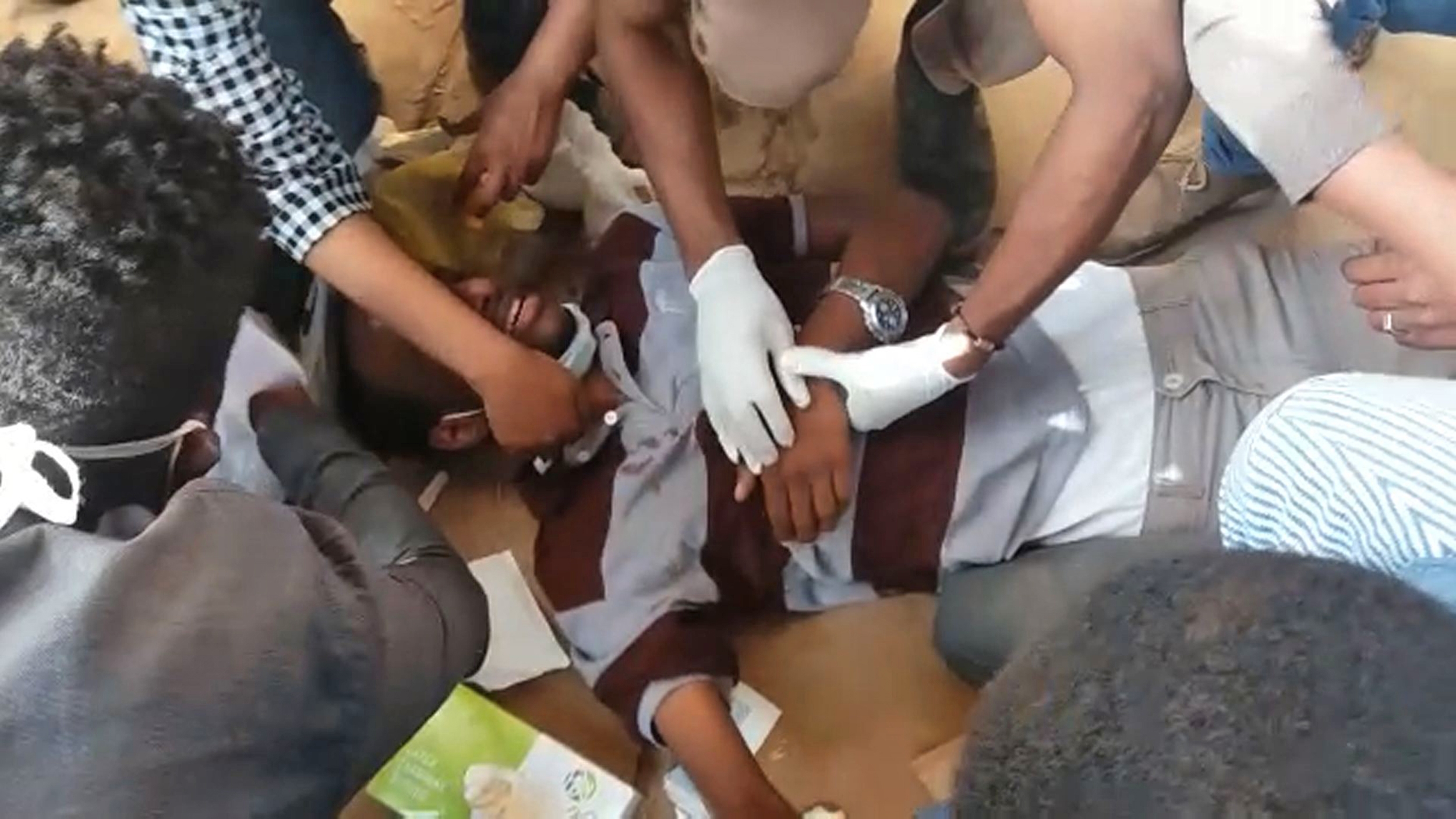 Medics look after an injured man after Sudanese police fired tear gas at protesters in Khartoum on 17 January (AFP)
