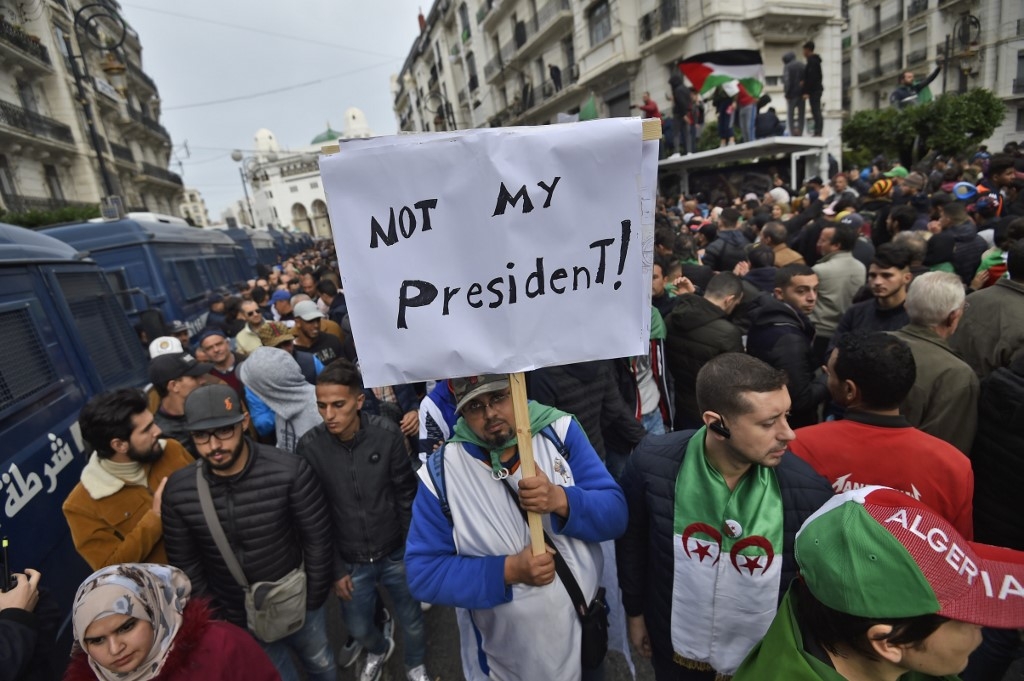 Manifestant, à Alger le vendredi 13 décembre, brandissant une pancarte où il affirme que le nouveau président algérien Abdelmadjid Tebboune «n'est pas son président »