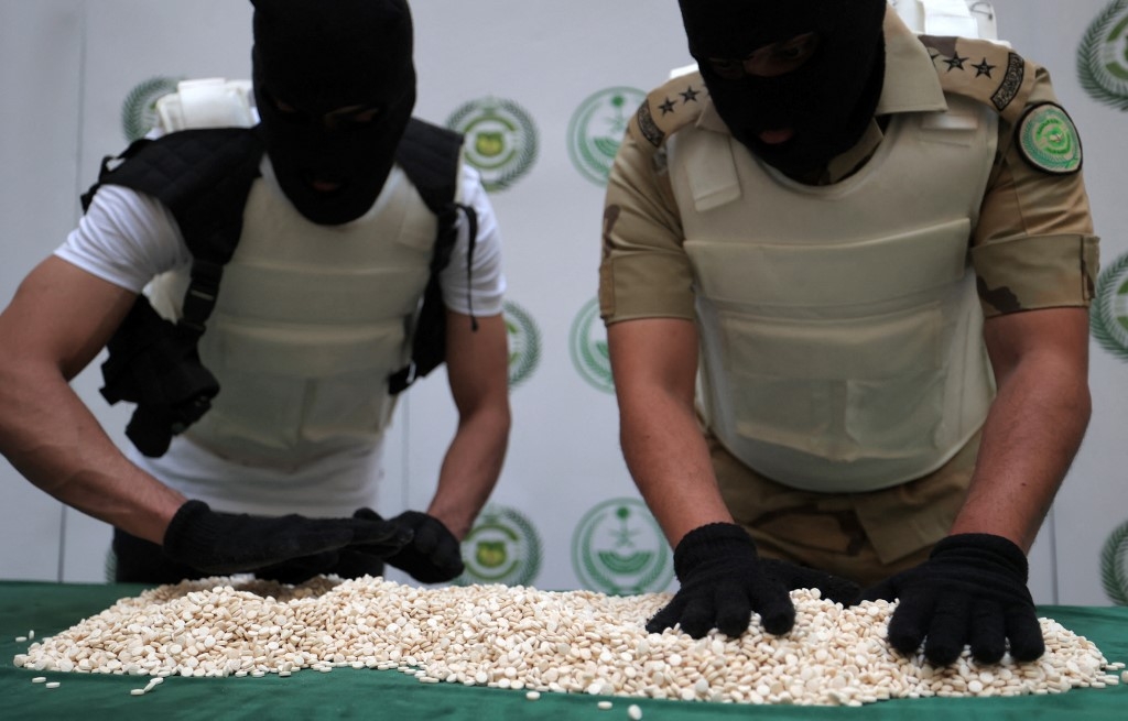 Des agents de la direction du contrôle des stupéfiants du ministère de l’Intérieur saoudien trient des comprimés de captagon saisis lors d’une opération spéciale à Djeddah, le 1er mars 2022 (AFP/Fayez Nureldine)