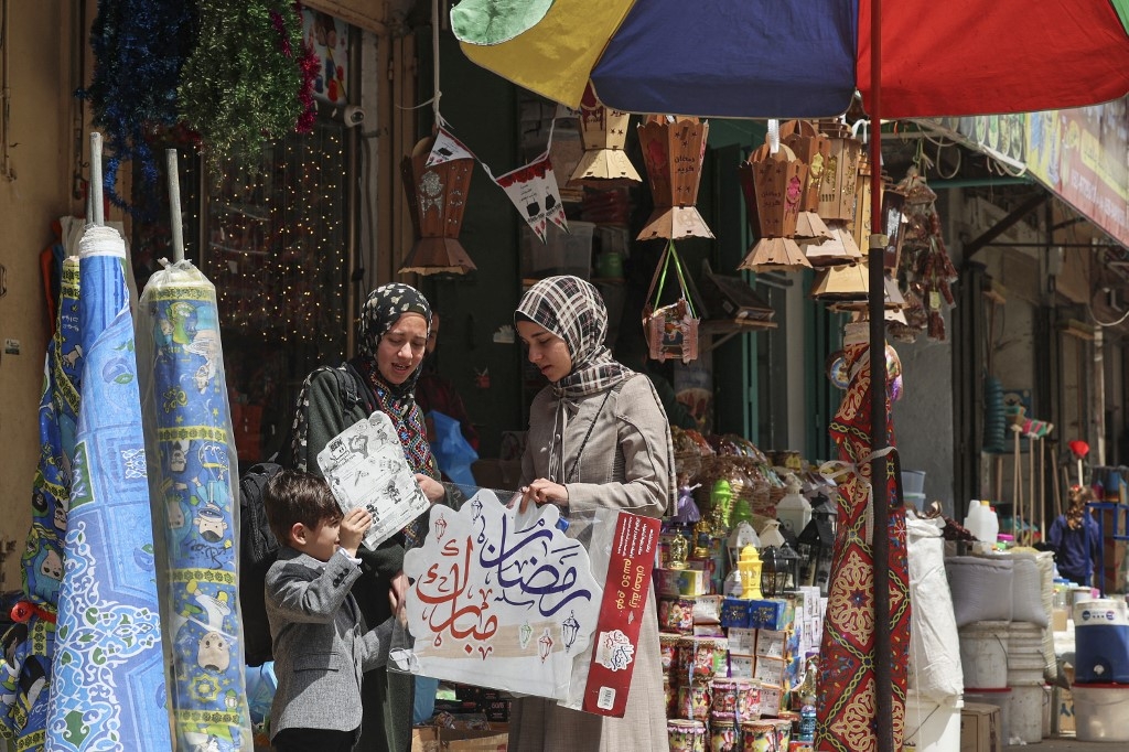 Des Palestiniennes font leurs emplettes pour le Ramadan dans un marché de Gaza, le 29 mars 2022 (AFP/Mohammed Abed)
