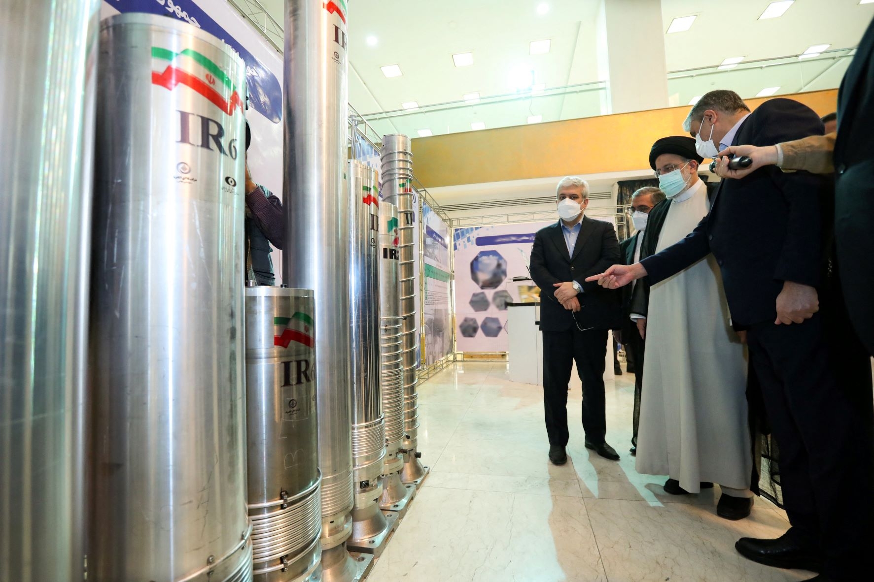 Iran's President Ebrahim Raisi (2-R) and Atomic Energy Organisation of Iran chief Mohammad Eslami (R) at a 'Nuclear Technology Day' event in Tehran, 9 April 2022 (AFP)