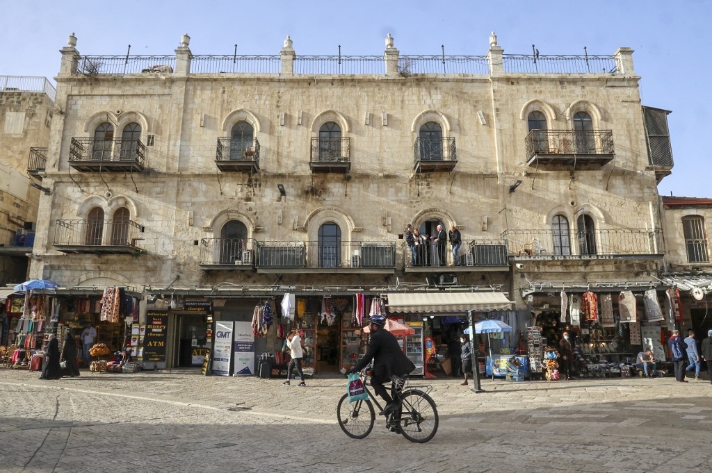 Un homme passe devant l’hôtel Petra, porte de Jaffa, dans la vieille ville de Jérusalem alors que les chefs religieux chrétiens se rencontrent à l’intérieur (AFP/Hazem Bader)