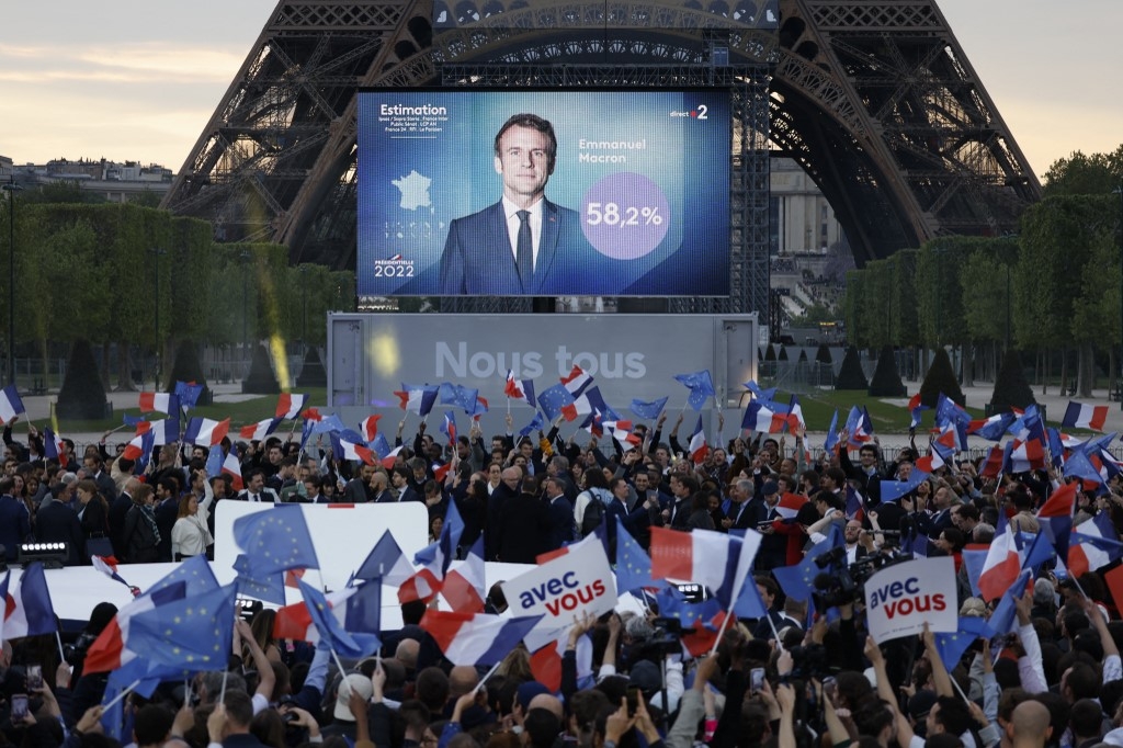 Les soutiens de Macron réagissent après la victoire de leur candidat au Champ de Mars, à Paris, le 24 avril 2022 (AFP/Ludovic Marin)
