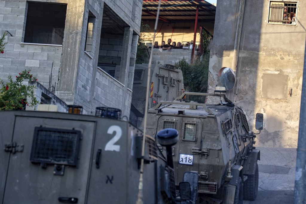 Israeli army's vehicles drive during a raid on a house in the town of Rummanah, near the flashpoint town of Jenin in the occupied West Bank on 8 May 2022. (AFP) 