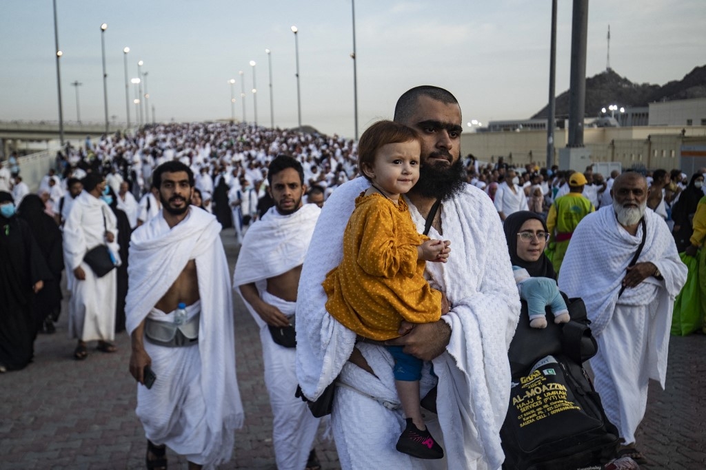 Des pèlerins musulmans traversent la vallée de Mina, près de La Mecque, dans l’ouest de l’Arabie saoudite, pour accomplir le rituel de la lapidation de Satan, qui marque le début de l’Aïd al-Adha, le 9 juillet 2022 (AFP)