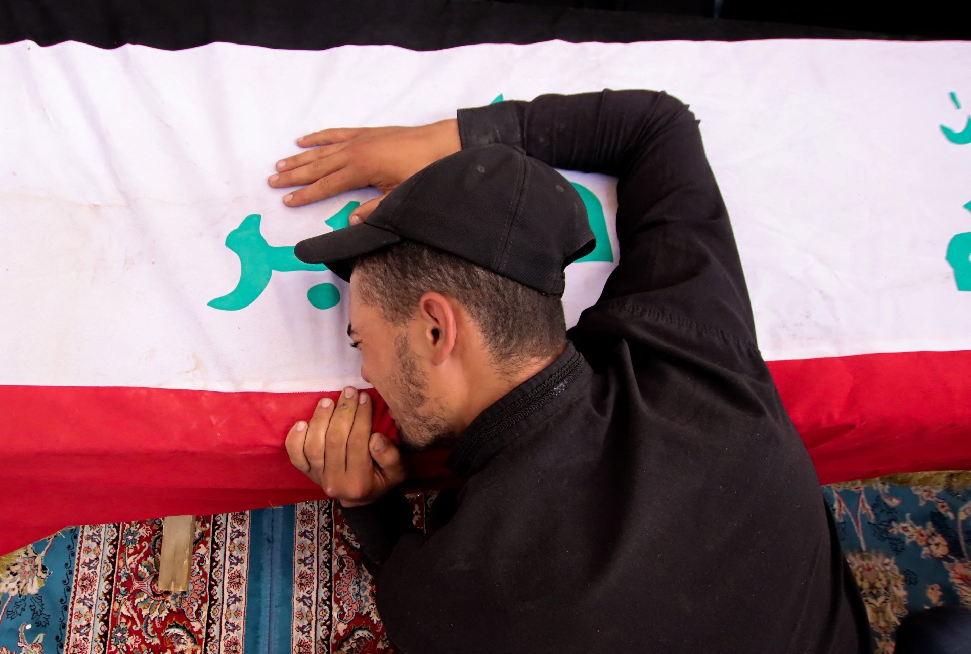 A mourner attends a mass funeral for supporters of Muqtada al-Sadr who were killed during clashes in Baghdad's Green Zone, at a cemetery in Najaf on 30 August (AFP)