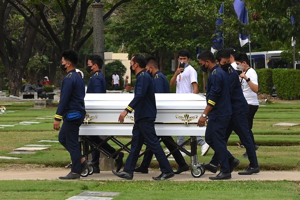 Men carry the coffin of Jullebee Ranara and grieve during her funeral at a cemetery in Las Pinas, Metro Manila on 5 February 2023 (AFP)