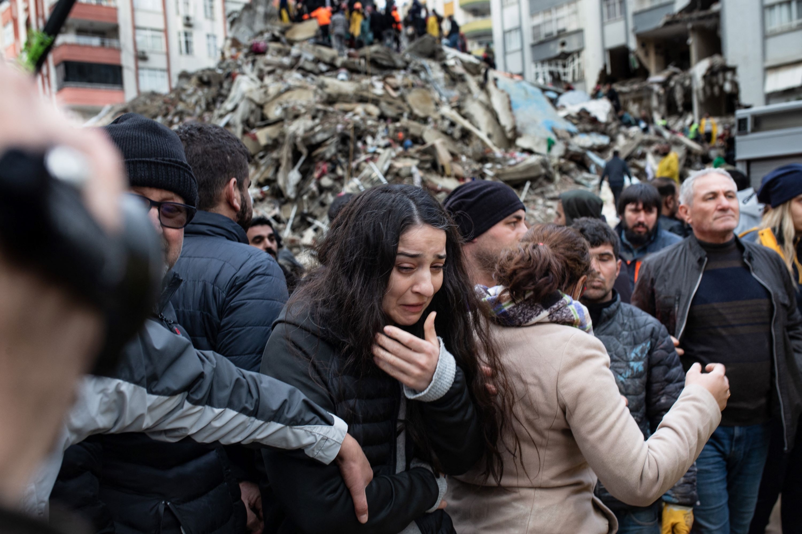 A woman reacts as rescuers search for survivors through the rubble of collapsed buildings in Adana, on February 6, 2023 after a 7,8 magnitude earthquake struck the country's south-east (AFP)