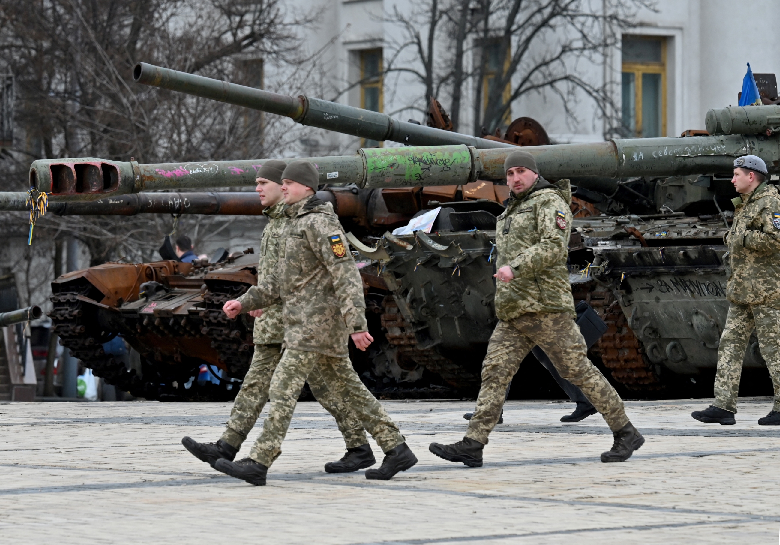 Des officiers ukrainiens passent devant des véhicules militaires russes détruits présentés dans une exposition en plein air à Kyiv, le 27 février 2023 (AFP)
