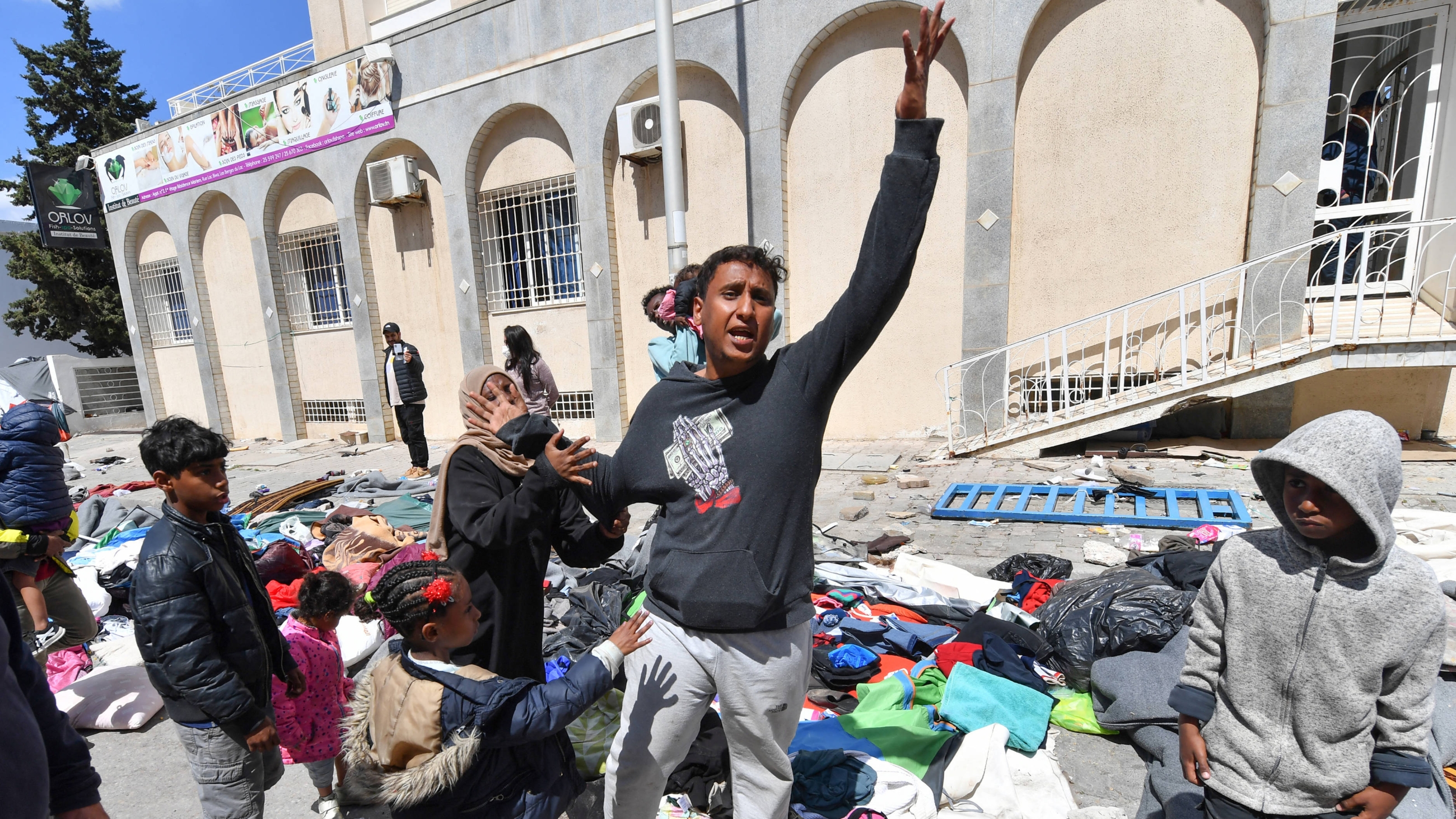 Migrants shout in front of the UNHCR headquarters in Tunis after the police dismantled a camp for refugees from sub-Saharan African countries on 11 April 2023 (AFP)