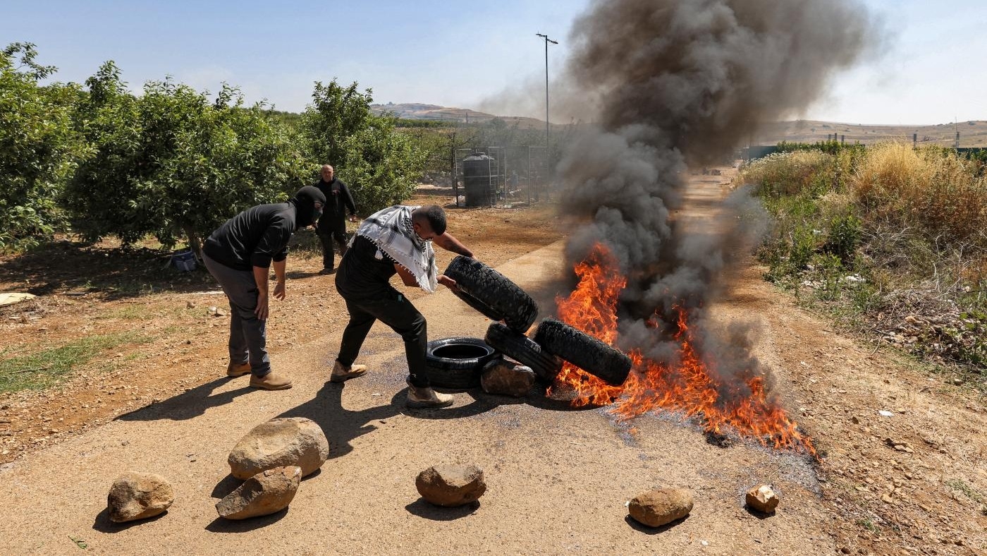 Members of the Druze community set tyres aflame as they protest against an Israeli wind turbine project planned across agricultural lands in their village of Majdal Shams in the Israeli-occupied Golan Heights on 21 June 2023 (AFP)