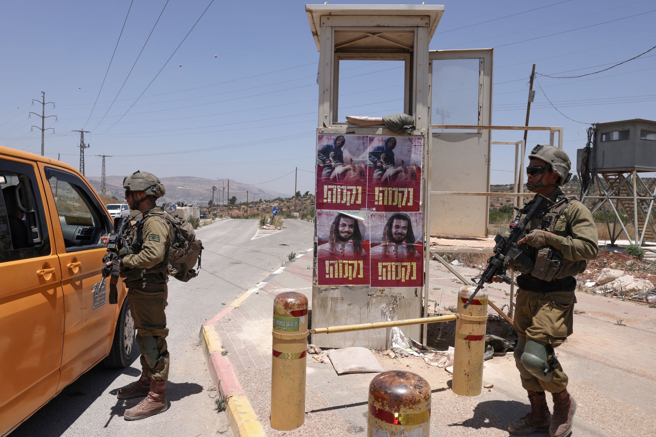 Israeli soldiers stand guard near the settlement of Kfar Tapuach in the occupied West Bank, on 25 June 2023 (AFP)