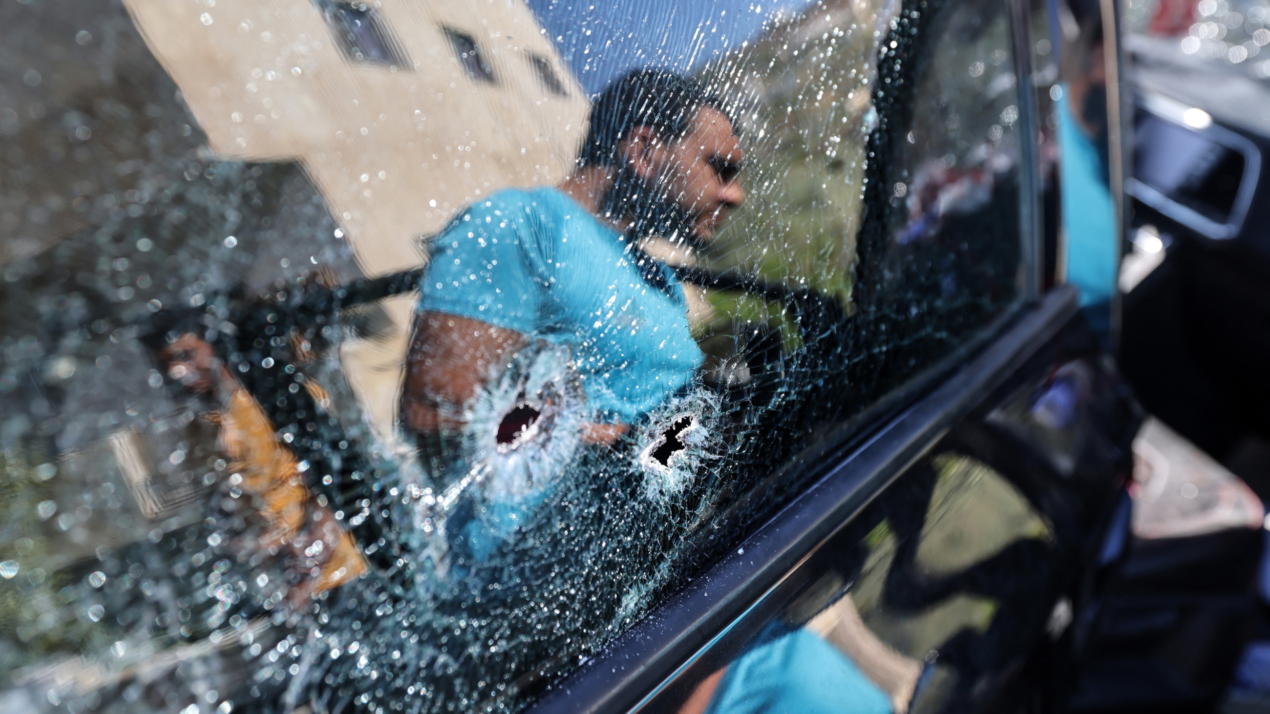 A man looks into a bullet-ridden car in which a Palestinian was killed late on 22 July 2023 by Israeli forces in the town of Sebastia near Nablus in the West Bank (AFP)