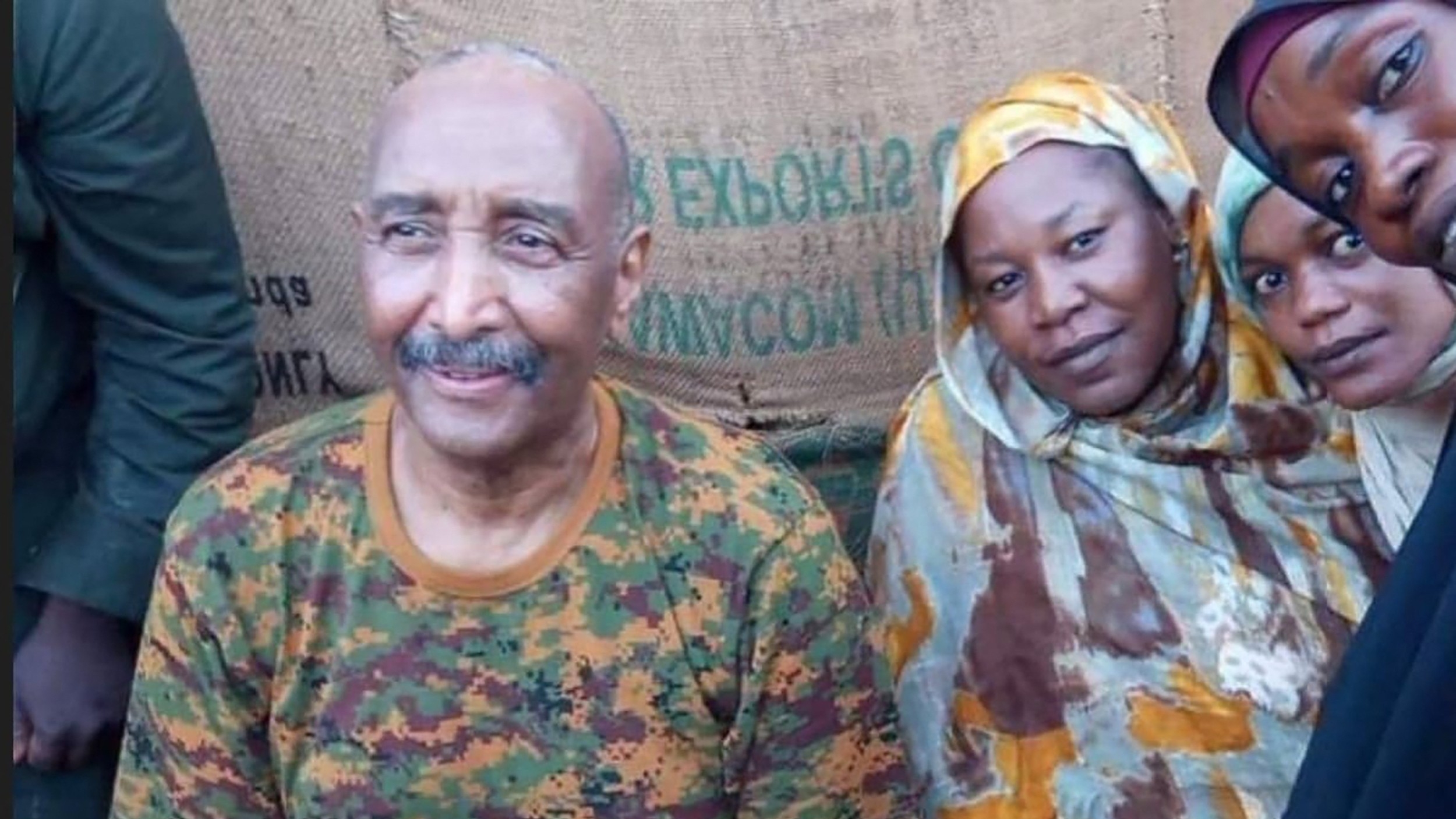 General Abdel Fattah al-Burhan posing for a picture with civilians in Khartoum during a tour of a neighbourhood in the capital on 24 August (AFP)