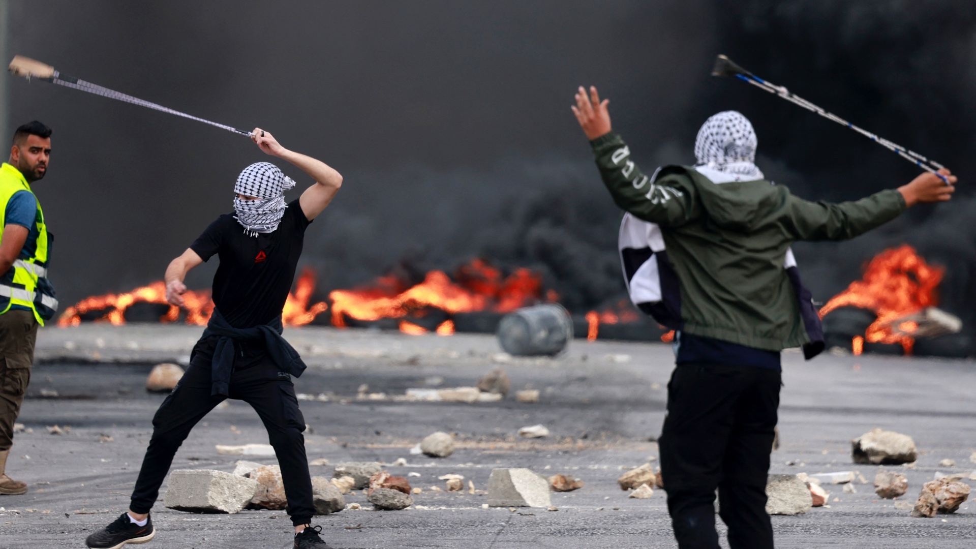 Palestinians hurl stones at Israeli forces during a demonstration against Israel's bombardment of Gaza, in the city of Ramallah in the occupied West Bank on 11 October 2023 (Jaafar Ashtiyeh/AFP)