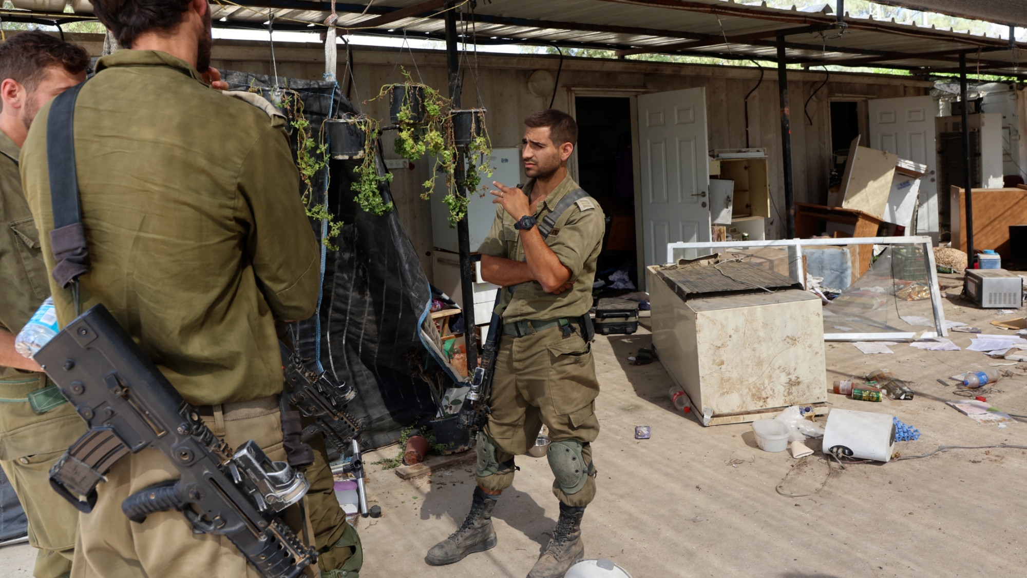 Israeli soldiers at a damaged house at the Nir Oz kibbutz, one of the Israeli communities near the Gaza Strip attacked on 7 October by the Palestinians, on 31 October 2023 (AFP)